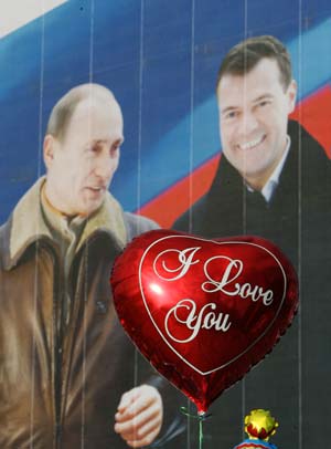 A balloon is seen in front of an election poster showing Russian President Vladimir Putin and presidential candidate Dmitry Medvedev in Moscow, Russia, March 1, 2008. Russia's presidential election will be held on March 2.(Xinhua Photo)
