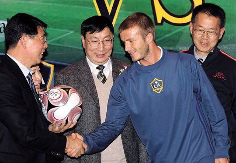 Los Angeles Galaxy midfielder David Beckham (right) shakes hands with Chinese coach Xu Genbao during a press conference in Shanghai yesterday. Beckham arrived in the city to play a friendly match with the Shanghai-Hong Kong Unitedteam with Xu as its coach on Wednesday. 