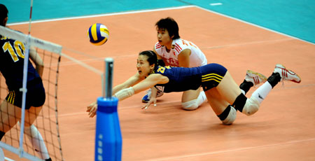 China's Zhou Suhong (Center) saves the ball during the sixth game of Sino-Cuban women's volleyball friendly series in Hangzhou of East China's Zhejiang Province March 2, 2008.