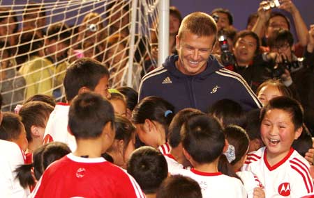 Los Angeles Galaxy's David Beckham interacts with young Chinese students during a promotional event in Shanghai, east China, March 3, 2008. Los Angeles Galaxy arrived in Shanghai on Sunday to play a match on March 5.