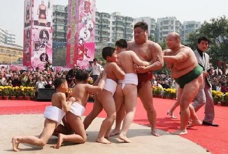 Children challenge Japanese sumo wrestlers during a show at Guangzhou Sculpture Park, on Sunday, March 2, 2008.