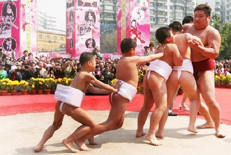 Children challenge a Japanese sumo wrestler during a show at Guangzhou Sculpture Park, on Sunday, March 2, 2008.