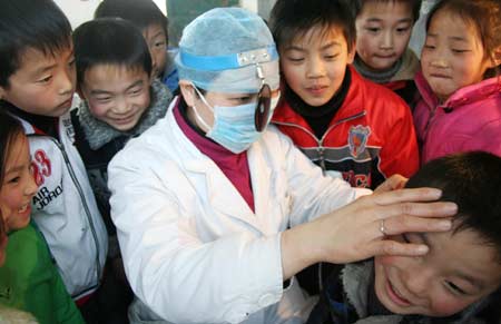 An aurist examines the ear for a child at a school in Hanshan County of east China's Anhui Province, March 3, 2008, the ninth National Ear Health Care Day. An activity of testing ears free of charge for children whose parents work in other cities was held in Hanshan on Monday. 