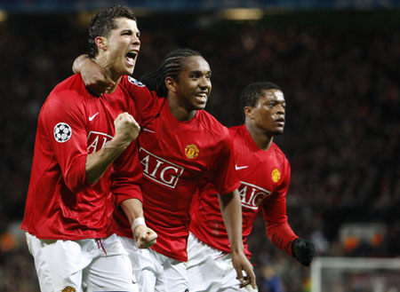 Manchester United&apos;s Cristiano Ronaldo (L) celebrates scoring with his team mates Anderson (C) and Patrice Evra against Lyon during their Champions League first knockout round, second leg soccer match at Old Trafford in Manchester, northern England, March 4, 2008. 