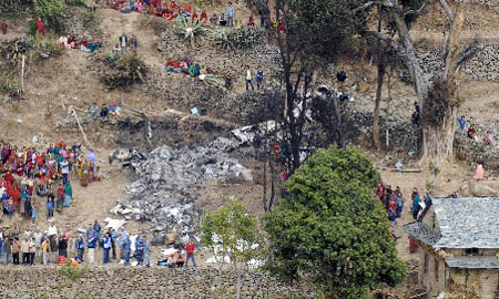 Villagers crowd near the crash site at a hill in Ramechhap, near Kathmandu, March 4, 2008. Ten people were killed when a helicopter carrying United Nations officials crashed in bad weather over hilly terrain near Nepal's capital on Monday, police and airport officials said.