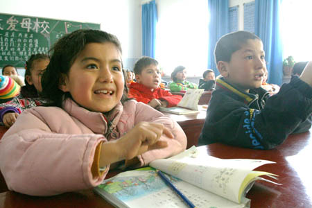 Pupils from families of poverty attend class with free textbooks at a school of Division 5 of Xinjiang Production and Construction Corps in Bole, northwest China's Xinjiang Uygur Autonomous Region, March 3, 2008. About 17,000 pupils of Division 5 were offered free textbooks from the government as the new term started. (Xinhua/Shen Zhijun)