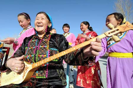 Ethnic Mongolian women sing and dance to welcome the upcoming International Women&apos;s Day in Qobuqsar County, Xinjiang Uigur Automomous Region, on March 2, 2008. 