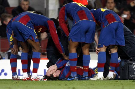 Barcelona's Lionel Messi lies down injured on the pitch as his teammates watch during their Champions League first knockout round, second leg soccer match against Celtic in Barcelona March 4, 2008.