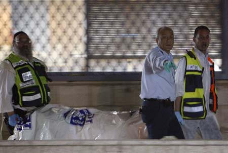 Israeli rescue workers carry a covered body from the scene of a shooting attack at a Jewish religious school in Jerusalem March 6, 2008. 