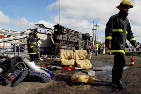  Firemen walk near the rail crossing where a passenger train crashed into a bus in Dolores, Buenos Aires province March 9, 2008.