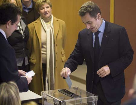 France's President Nicolas Sarkozy (R) casts his ballot in the first round of local elections in Paris March 9, 2008.