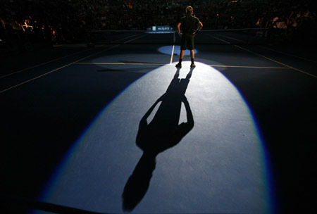 Roger Federer of Switzerland stands in a spotlight as he is introduced prior to his exhibition tennis match against Pete Sampras of the U.S. at New York's Madison Square Garden, March 10, 2008. 