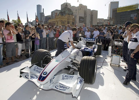 Race fans watch a BMW Formula One car being fired up in front of Melbourne's landmark Flinders station at a F1 warm-up party in Melbourne yesterday. The Australian Grand Prix, the first race of the 2008 season, takes place on Sunday.