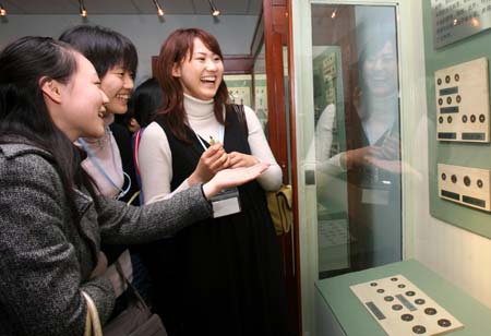 Accompanied by a Chinese student (L), two Japanese students (R, C), visit a museum of ancient currency at East China Normal University in Shanghai of China, March 11, 2008. A total of 1,000 Japanese youth arrived in China on Monday for a seven-day tour of the country to mark the start of the China-Japan Friendly Exchange Year of the Youth. The Japanese delegation, breaking into small groups, will respectively visit such cities as Shanghai and Hangzhou in the east, Chongqing and Chengdu in the west, Guangzhou in the south and Dalian in the northeast and hold get-togethers with their Chinese peers.