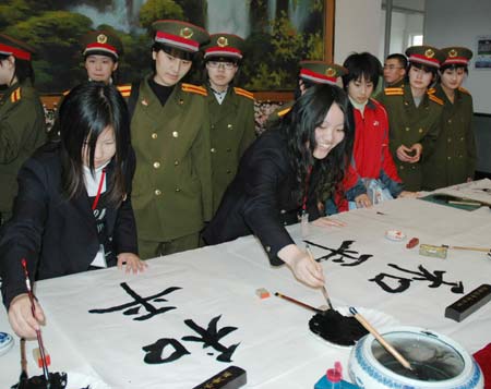  Japanese students write Chinese characters reading Peace during their visit to a school in Dalian of northeast China's Liaoning Province on March 11, 2008. A total of 1,000 Japanese youth arrived in China on Monday for a seven-day tour of the country to mark the start of the China-Japan Friendly Exchange Year of the Youth. The Japanese delegation, breaking into small groups, will respectively visit such cities as Shanghai and Hangzhou in the east, Chongqing and Chengdu in the west, Guangzhou in the south and Dalian in the northeast and hold get-togethers with their Chinese peers.