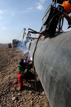 A worker solders part of the second west-to-east natural gas transmission pipeline at the construction site in Fengle Town of Wuwei City, northwest China's Gansu Province. The pipeline will carry natural gas from Turkmenistan and China's Xinjiang Uygur Autonomous Region to the central and west China’s areas as well as the Yangtze and Pearl River deltas. The 9,102-kilometer pipeline that is under construction consists of a main line and eight sub-lines traversing 14 provinces, autonomous regions and the municipality Shanghai. The pipeline’s designed gas transmission capacity is 30 billion cubic meters annually and the total investment on the project is 142.2 billion yuan (about 20 billion U.S. dollars) 