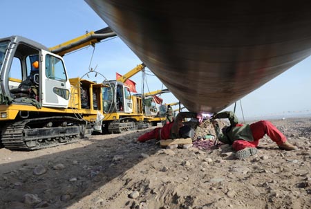 Workers solder part of the second west-to-east natural gas transmission pipeline at the construction site in in Fengle Town of Wuwei City, northwest China's Gansu Province. The pipeline will carry natural gas from Turkmenistan and China's Xinjiang Uygur Autonomous Region to the central and west China’s areas as well as the Yangtze and Pearl River deltas. The 9,102-kilometer pipeline that is under construction consists of a main line and eight sub-lines traversing 14 provinces, autonomous regions and the municipality Shanghai. The pipeline’s designed gas transmission capacity is 30 billion cubic meters annually and the total investment on the project is 142.2 billion yuan (about 20 billion U.S. dollars) 