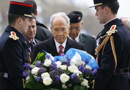 Israel's President Shimon Peres (C) lays a wreath at the Tomb of the Unknown Soldier under the Arc de Triomphe in Paris March 11, 2008. Shimon Peres is on a four-day state visit in France. 