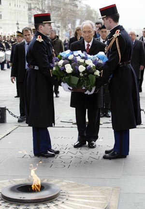 Israel's President Shimon Peres (C) lays a wreath at the Tomb of the Unknown Soldier under the Arc de Triomphe in Paris March 11, 2008. Shimon Peres is on a four-day state visit in France. 