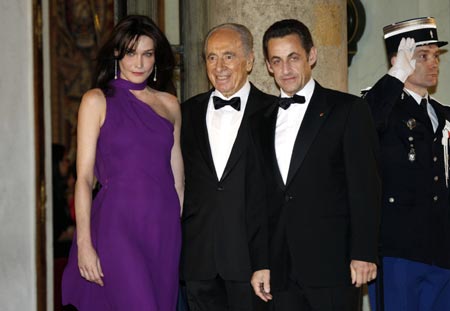 France's President Nicolas Sarkozy (R) and his wife Carla Bruni-Sarkozy (L) greet Israel's President Shimon Peres as he arrives at the Elysee Palace, March 10, 2008. 