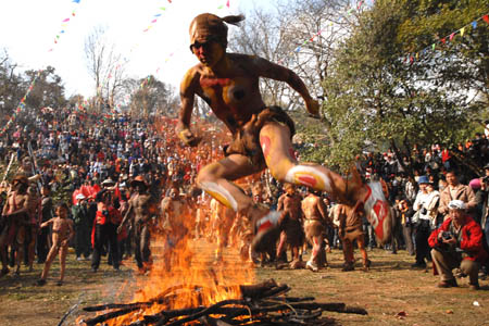 A man jumps over a needfire during a fire-worshipping ceremony in Mi'le County, Southwest China's Yunnan Province, March 10, 2008. The local residents of Yi ethnic group of Mi'le County hold a mass annual festa on the 3rd day of the 2nd month in the Chinese Lunar calendar, which was an ancient fire-worshipping ceremony handed down from their ancestors. 