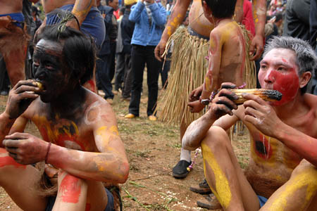 People eat toasted corns during a fire-worshipping ceremony in Mi'le County, Southwest China's Yunnan Province, March 10, 2008. The local residents of Yi ethnic group of Mi'le County hold a mass annual festa on the 3rd day of the 2nd month in the Chinese Lunar calendar, which was an ancient fire-worshipping ceremony handed down from their ancestors. 