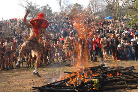 A man dances around a needfire during a fire-worshipping ceremony in Mi'le County, Southwest China's Yunnan Province, March 10, 2008. The local residents of Yi ethnic group of Mi'le County hold a mass annual festa on the 3rd day of the 2nd month of Chinese Lunar calendar, which was a traditional worshipping ceremony handed down from their ancestors.