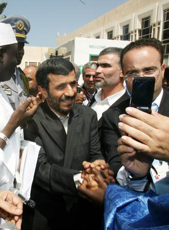Iranian President Mahmoud Ahmadinejad (C) shakes hands with his supporters during the 11th Session of the Islamic Summit Conference in Dakar, capital of Senegal, March 13, 2008. With the theme of "Islam in the 21st Century", the 57-nation Organization of Islamic Conference (OIC) opened its two-day 11th Session of the Islamic Summit Conference on Thursday, during which the revising of the charter will be discussed. 