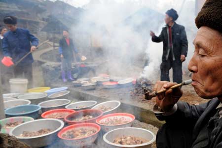Local residents prepare dinner after the celebration of Jingqiao festival (a feast dedicated to worship ancestors and bridges) in Jiuyang village of Jianhe County in Miao and Dong Autonomous Prefecture of southwest China's Guizhou province, on March 10, 2008.
