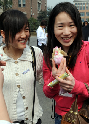 A Japanese student (R) displays a gift she received from Chinese students in Hangzhou, capital of east China's Zhejiang province, on March 12, 2008.
