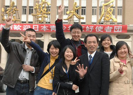 Japanese students and Wang Tiangang (4th R), representative of Shenyang citizens, pose for a group photo in Shenyang, capital of northeast China's Liaoning Province, on March 12, 2008. 