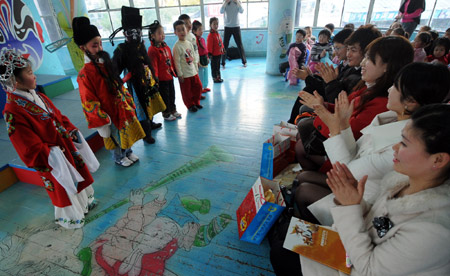 Japanese students watch Chinese children perform Beijing Opera in a kindergarten in Hangzhou, capital of east China's Zhejiang province, on March 12, 2008. 