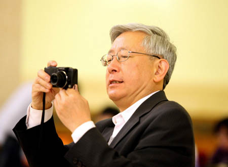 A Hong Kong journalist takes photos prior to Chinese Foreign Minister Yang Jiechi's meeting with the press at the Great Hall of the People in Beijing, capital of China, March 12, 2008. 