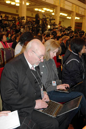 Foreign journalists work on their laptops during Chinese Foreign Minister Yang Jiechi's meeting with the press at the Great Hall of the People in Beijing, capital of China, March 12, 2008. 