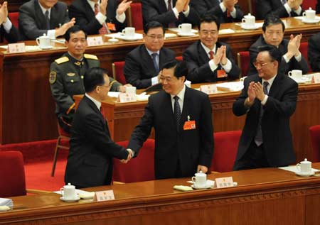 Chinese President Hu Jintao (C front) shakes hands with Wen Jiabao (L front) after Wen was approved to be premier of China's State Council according to the result of a secret ballot by legislators during the sixth plenary meeting of the First Session of the 11th National People's Congress (NPC) in Beijing, capital of China, March 16, 2008. (Xinhua/Li Xueren) 