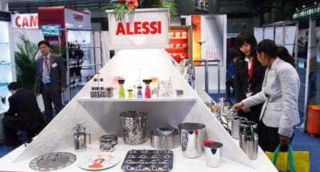 Visitors look at the tableware for restaurants during the 14th China International Exhibition for Hotel & Restaurant Facilities, Equipment & Services, Food & Beverages that opened at the China World Trade Center Exhibition Hall in Beijing, capital of China, on March 16, 2008.