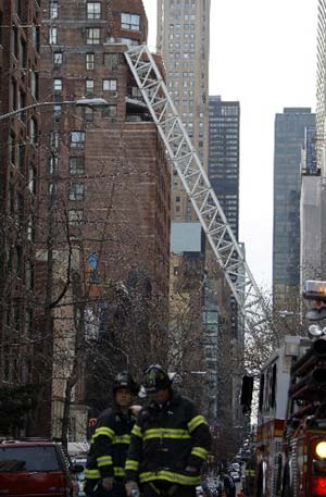 A section of collapsed crane protrudes from a crushed building on 50th Street near Second Avenue Saturday, March 15, 2008 in New York. 
