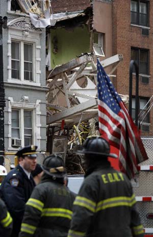 A section of collapsed crane protrudes from a crushed building on 50th Street near Second Avenue Saturday, March 15, 2008 in New York.