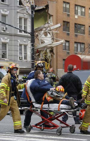 An injured firefighter is evacuated at the site of a crane collapse in New York on March 15, 2008. 