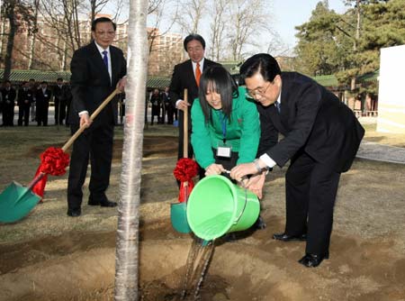 Chinese President Hu Jintao (1st R) waters a tree with a Japanese representative after planting it during the opening ceremony of the China-Japan Friendly Exchange Year of the Youth at Renmin University in Beijing, March 15, 2008. 
