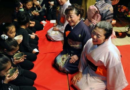 Japanese tea ceremony artists smile as the spectators taste the tea during a performance of the art of tea making in Nanjing, capital of east China's Jiangsu Province, on March 16, 2008. A Japanese delegation dedicated to a project of planting 5,000 cherry trees in a garden in Nanjing is now in China for a visit. 