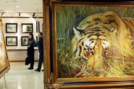 Visitors view the paintings at the painting exhibition of artists from the Democratic People's Republic of Korea (DPRK) held in Dalian, a coastal city in northeast China's Liaoning province, March 16, 2008. 