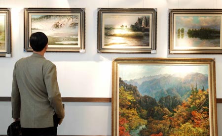 A visitor views the paintings at the painting exhibition of artists from the Democratic People's Republic of Korea (DPRK) held in Dalian, a coastal city in northeast China's Liaoning province, March 16, 2008. 