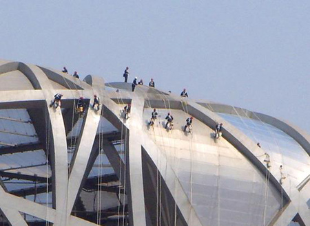 Workers clean the outside part of the National Stadium, or 'Bird's Nest' on Sunday, March 16, 2008, to welcome the Good Luck Beijing Olympic test games that will be held in mid April in Beijing. 