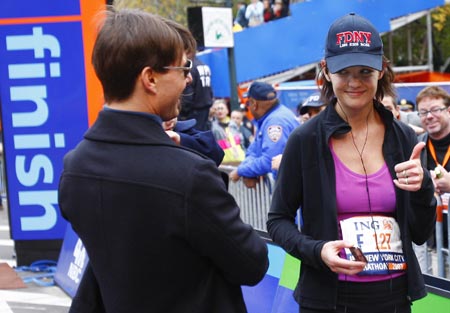 Actress Katie Holmes gives her husband Tom Cruise the thumbs-up after she finished the 2007 New York City Marathon November 4, 2007.