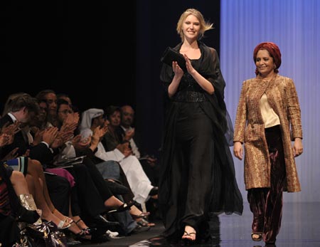 A model applauds as she displays an outfit by Saudi designer Amina Al Jassim (R) during the Abu Dhabi Fashion Week at Emirates Palace March 18, 2008.