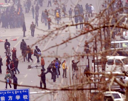 Rioters throw stones to vehicles and stores during the unrest in Lhasa, capital of southwest China's Tibet Autonomous Region, on March 14, 2008.