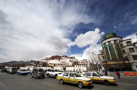  Vehicles run on a street in front of Potala Palace in Lhasa, capital of southwest China's Tibet Autonomous Region, March 19, 2008. 