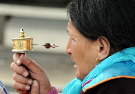  A Tibetan woman prays in front of the Jokhang Lamasery in Lhasa, capital of southwest China's Tibet Autonomous Region, March 19, 2008.