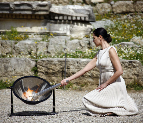 Maria Nafpliotou, the High Priestess of the Flame-lighting Ceremony, lights the Olympic flame at a rehearsal before the Lighting Ceremony for the Beijing Olympic Games in ancient Olympia, Greece March 22, 2008. The ceremony will be officially held at 11 o' clock a.m. on Monday local time. [Xinhua]
